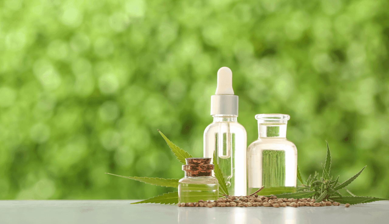 Extrakt Flaschen auf weißem Tisch vor grünem Hintergrund